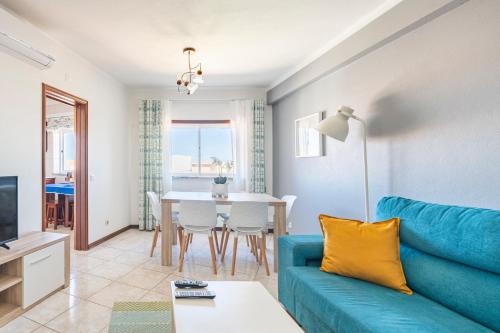a living room with a blue couch and a table at Apartamentos Casal Ventoso in Pedrógão