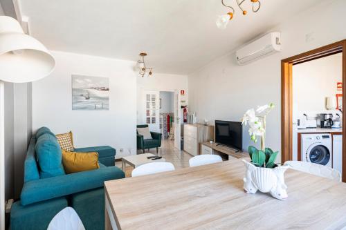 a living room with a table and a blue couch at Apartamentos Casal Ventoso in Pedrógão