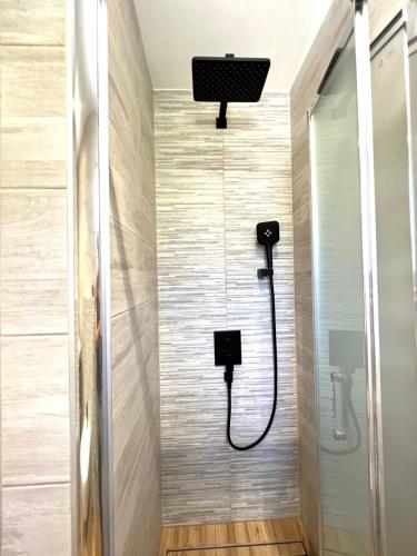 a shower with a shower head in a bathroom at Vila Vera Seafront Apartments in Sumartin