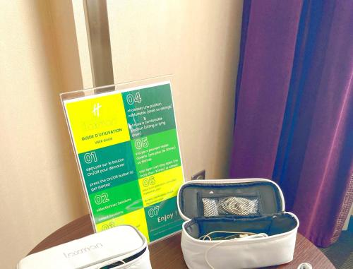 a suitcase sitting on a table next to a sign at Holiday Inn Toulouse Airport by IHG in Blagnac