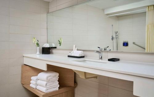 a bathroom with a sink and a mirror and towels at Radisson Blu Toronto Downtown in Toronto