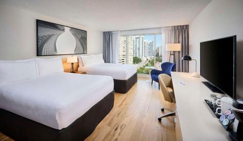 a hotel room with two beds and a flat screen tv at Radisson Blu Toronto Downtown in Toronto