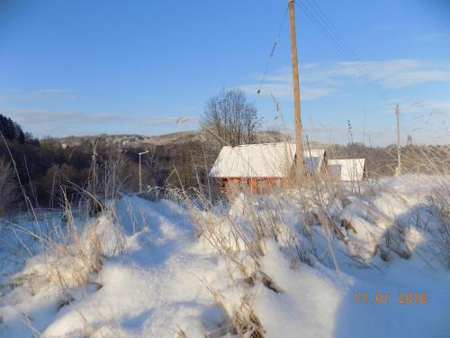 a house in a snow covered field with a pole at Chatka w gorach in Lewin Kłodzki