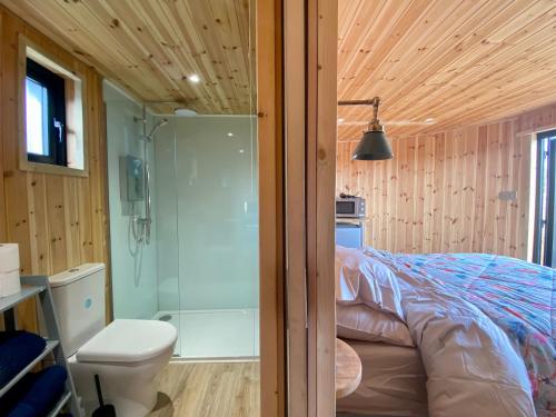 a bedroom with a bed and a shower and a toilet at Silo Blue in Great Dunmow