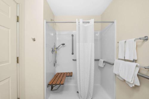 クイーンズベリーにあるQuality Innの白いバスルーム(シャワー、ベンチ付)