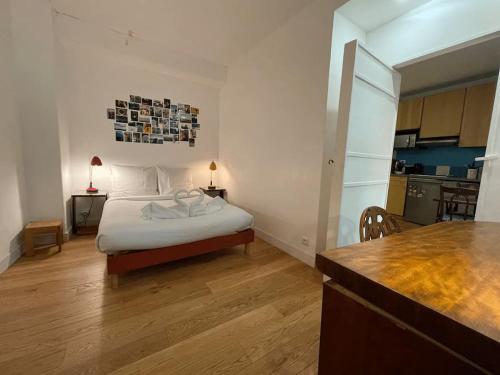 une petite chambre avec un lit et une cuisine dans l'établissement Nice flat in face to Seine River, à Paris