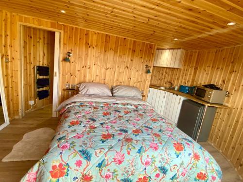 a bedroom with a bed in a wooden room at Silo Blue in Great Dunmow