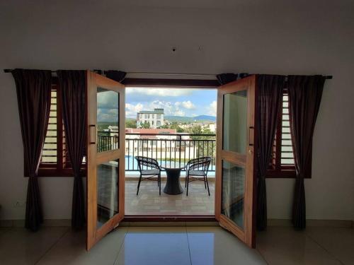 a room with a balcony with a table and chairs at SS Luxury Comforts A 2bhk service apartment in Chikmagalūr