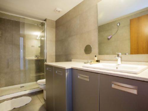 a bathroom with a sink and a toilet and a mirror at Loft Pere IV in Barcelona