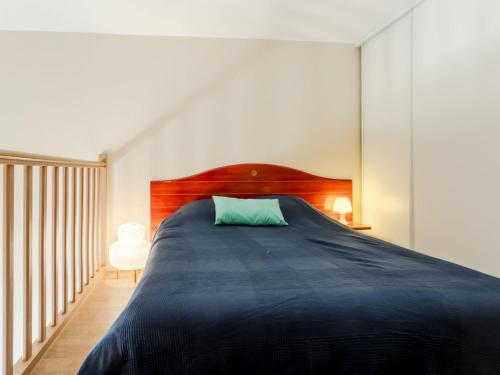 une chambre avec un grand lit avec une tête de lit en bois dans l'établissement Apartment Port Guillaume-17 by Interhome, à Dives-sur-Mer