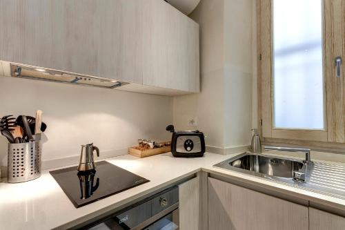 フィレンツェにあるConce Apartment by Mamo Florenceのシンクと電子レンジ付きのキッチン