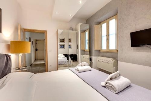 フィレンツェにあるConce Apartment by Mamo Florenceのベッドと壁にテレビが掛かった寝室