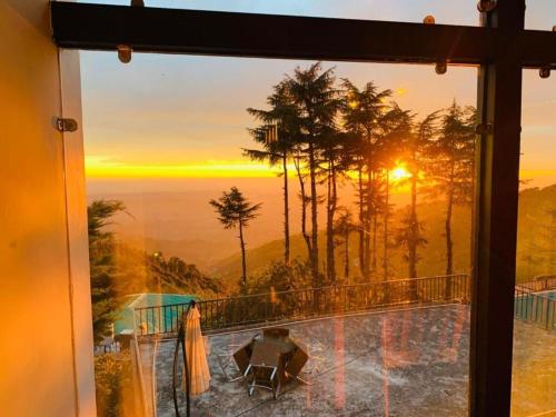 a view of a sunset from a window at Pema Thang Guest House Mcleodganj in Dharamshala