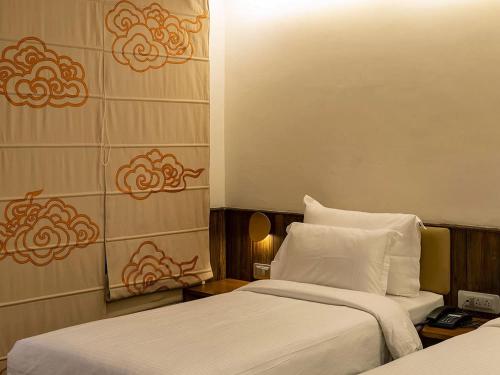 a hotel room with two beds with white sheets at Pema Thang Guest House Mcleodganj in Dharamshala