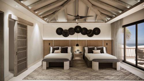 a bedroom with two beds and a ceiling fan at Zemi Miches Punta Cana All-Inclusive Resort, Curio by Hilton in Miches