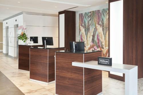 an office lobby with a reception desk and a mural at DoubleTree by Hilton Miami North I-95 in Miami