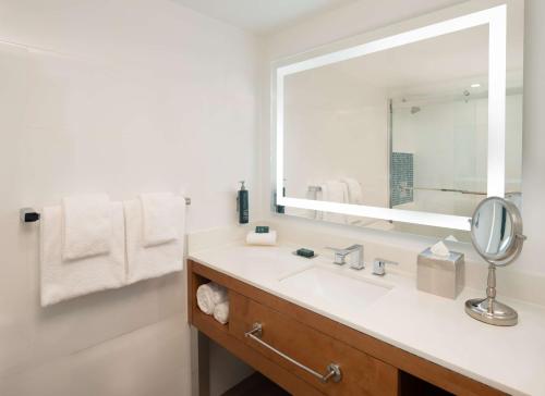 a bathroom with a sink and a large mirror at DoubleTree by Hilton Miami North I-95 in Miami