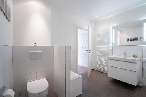 een witte badkamer met een toilet en een wastafel bij Objekte im Umland Villa Meeresrauschen in Pelzerhaken