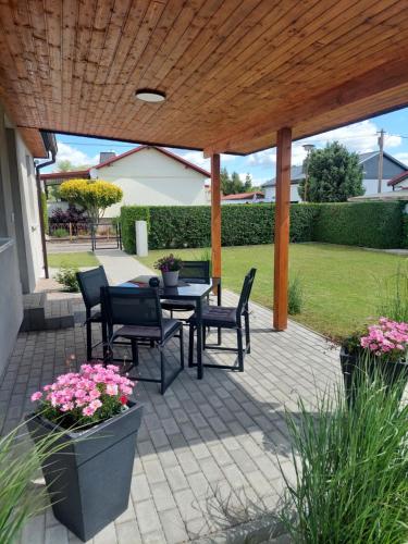 a patio with a table and chairs under a wooden pergola at Haus Angel-am See in Heldrungen
