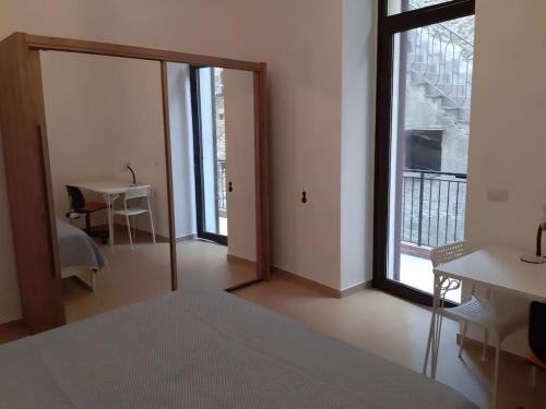 a room with a bed and a table and a window at A 20 passi dal mare in Giardini Naxos