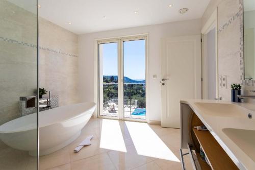 une salle de bain avec baignoire et une grande fenêtre dans l'établissement VILLA SAVANNAH VI4356 By Riviera Holiday Homes, à Nice