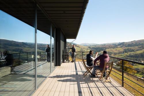 a group of people sitting on a deck looking out at the mountains at Krasnyk Resort in Krasnik