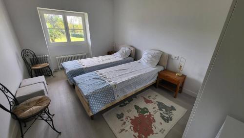 une petite chambre avec deux lits et une fenêtre dans l'établissement Urrugne, Croix des bouquets, au 1er étage d'une bâtisse Basque, APPT 10 pers avec piscine, à Urrugne
