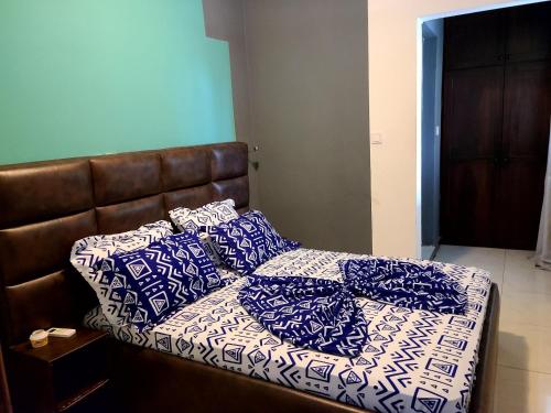 a bed with blue and white pillows on it at Furnished Luxury 2-bedroom apartment -Vanguard X ,Cloud 9 in Douala