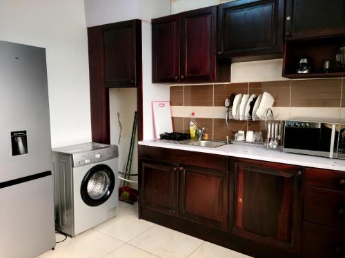 a kitchen with a sink and a washing machine at Furnished Luxury 2-bedroom apartment -Vanguard X ,Cloud 9 in Douala