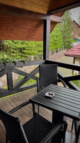 a black table and chairs on a wooden deck at GORGANY resort & SPA in Yablunytsya