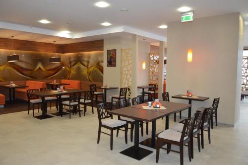 jadalnia ze stołami i krzesłami w restauracji w obiekcie Hotel Via Baltica w mieście Łomża