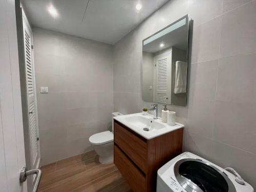 a bathroom with a sink and a toilet and a mirror at Apartamento Trini en Son Bou, frente al mar, perfecto para vacaciones in Alaior
