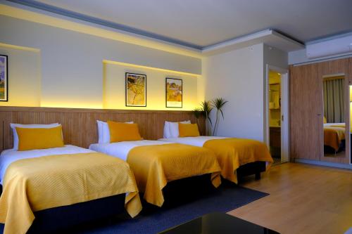 a hotel room with two beds with yellow blankets at Dugi Hotel in Istanbul