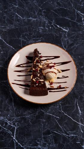 a plate with a piece of chocolate cake and ice cream at Pema Thang Guest House Mcleodganj in Dharamshala