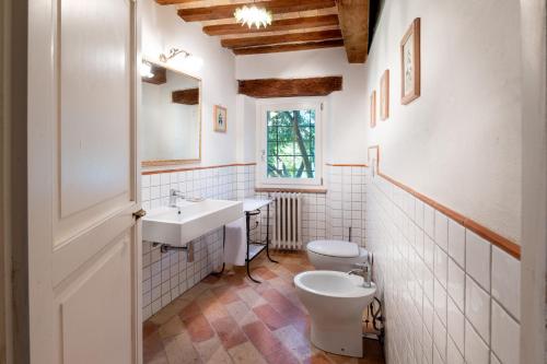 a bathroom with a sink and a toilet and a window at Verde Immenso - Pool BBQ Relax in Molino Abbadia