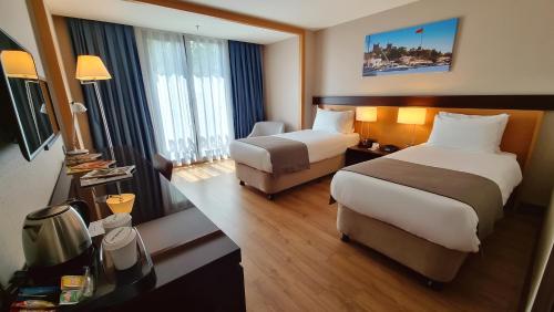 una camera d'albergo con due letti e una sedia di Port Bosphorus a Istanbul