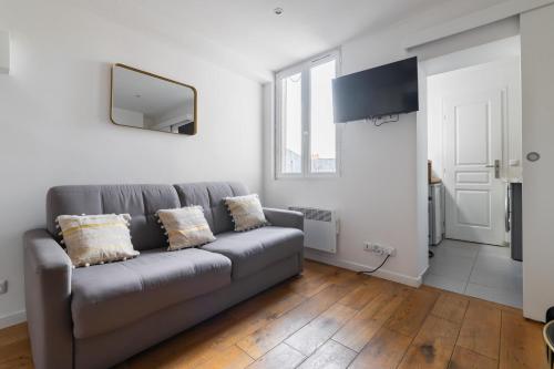 un salon avec un canapé et une télévision dans l'établissement Studio cosy metro saint Paul - Paris 3 - 2P - FLAT-GUEST, à Paris