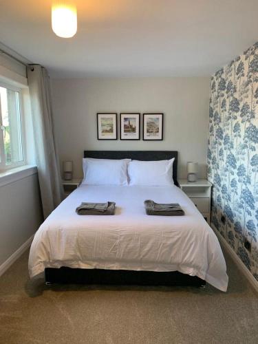 a bedroom with a large bed with two towels on it at 3 Bedroom Cosy Home In Fife in Cardenden