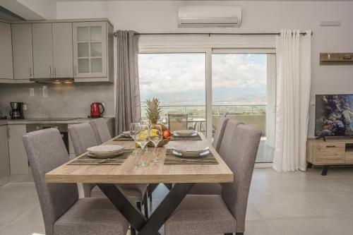 a dining room with a table with chairs and a window at Leonidas Family Apartment 1 in Pómbia
