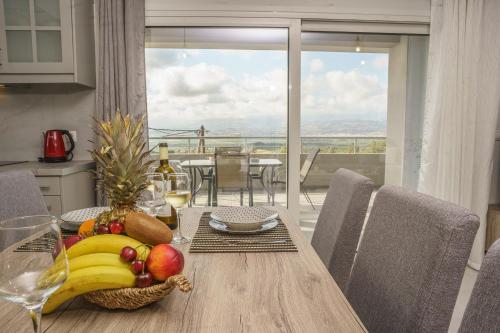 a wooden table with a bowl of fruit on it at Leonidas Family Apartment 1 in Pómbia