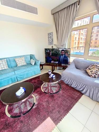 a living room with two tables and a couch at روز الشاطي إطلالة بحرية Rose Sea View in King Abdullah Economic City