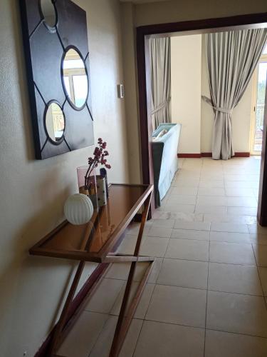 a room with a glass table and a mirror at روز الشاطي إطلالة بحرية Rose Sea View in King Abdullah Economic City