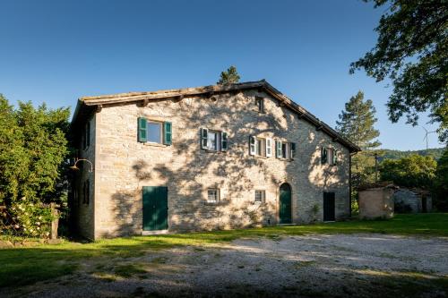 an old stone house with green doors and trees at Verde Immenso - Pool BBQ Relax in Molino Abbadia