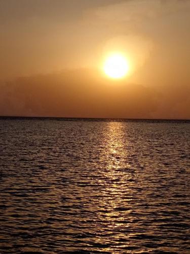 a sunset over the ocean with the sun setting at روز الشاطي إطلالة بحرية Rose Sea View in King Abdullah Economic City