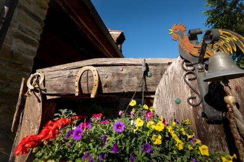 a wooden bird house with flowers and a bell at Verde Immenso - Pool BBQ Relax in Molino Abbadia