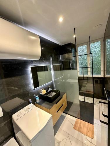 une salle de bain avec une douche avec un lavabo et un miroir dans l'établissement Suite Cosy Chic, à Saint-Claude