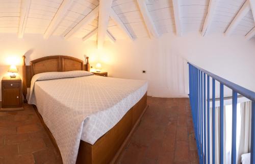 a bedroom with a bed with a white bedspread at Hotel Vecchia Marina in Àrbatax