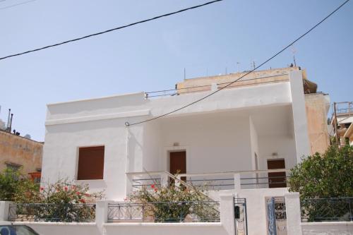 a white house with a balcony in front of it at Petra Casa in Sitia