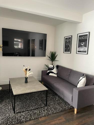 a living room with a couch and a table at Lovely 2 Bed Full House By The Beach in Liverpool