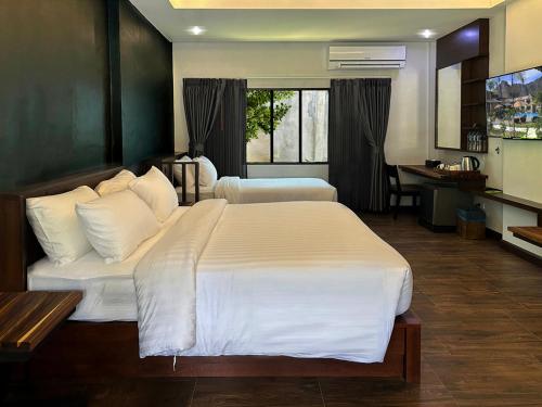 a hotel room with two beds and a desk at Eco Inn Cottage by Aonang Hill in Ao Nang Beach